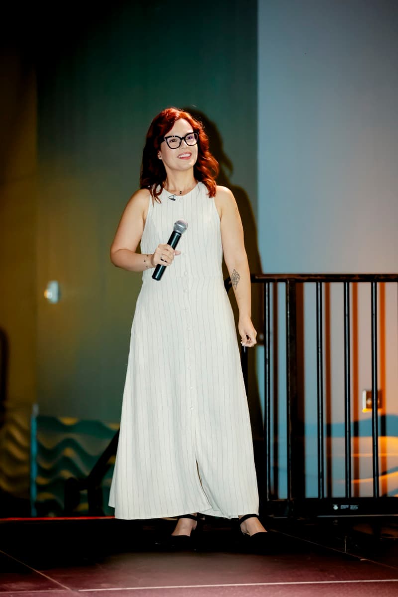 Mai hablando en tarima durante un evento de Credit Café